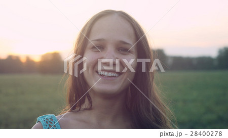 Portrait of pretty woman at sunset in the field 28400278