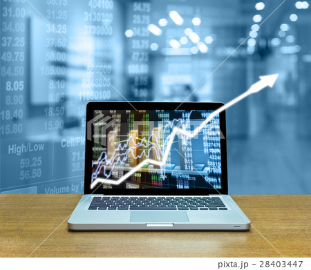 Stock exchange market trading graph over the screen of computer laptop on wood table over the photo blurred of trading graph background, business marketing trade concept 28403447