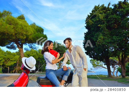 Portrait of happy young love couple on scooter Portrait of happy young love couple on scooter 28403850