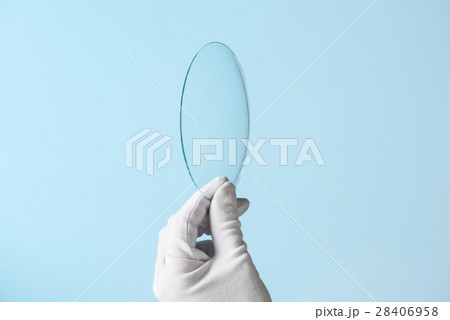 Scientist hand in glove show circle piece of new research prototype of transparent clear glass or plastic material 28406958