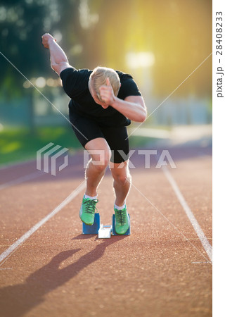 Sprinter leaving starting blocks on the running 28408233