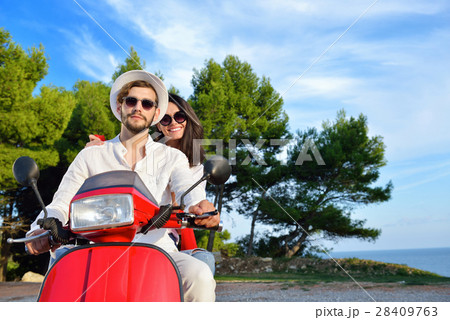 Happy couple on a scooter at summer vacation Happy couple on a scooter at summer vacation 28409763