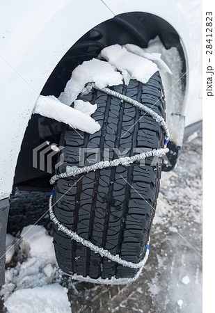 Snow chain puts on a wheel of a car 28412823