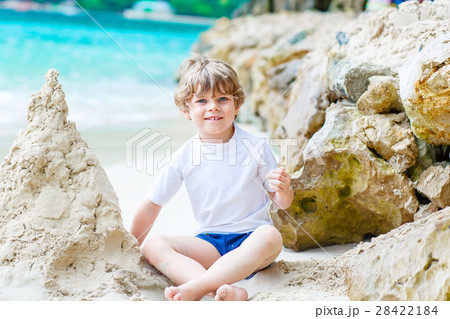 Little kid boy building sand castle on tropical Little kid boy building sand castle on tropical 28422184