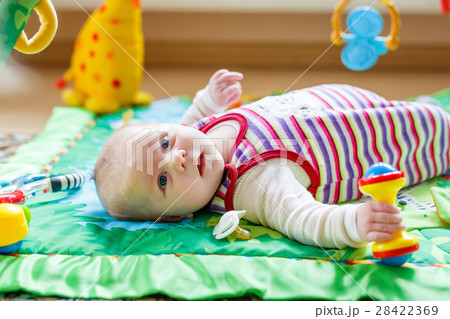 Cute adorable newborn baby playing on colorful toy 28422369