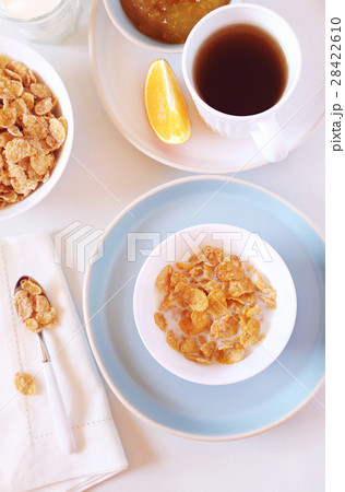 Corn flakes in bowl, milk and tea 28422610