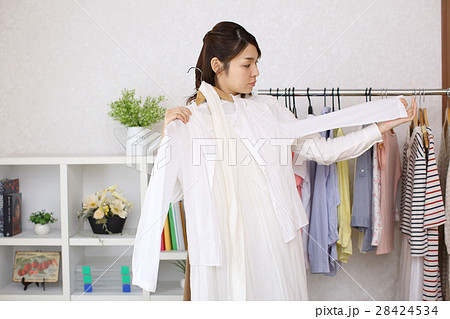 部屋で洋服を選ぶ女性 28424534