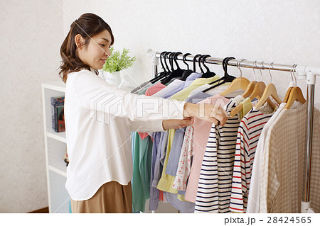 部屋で洋服を選ぶ女性の写真素材 28424565 Pixta