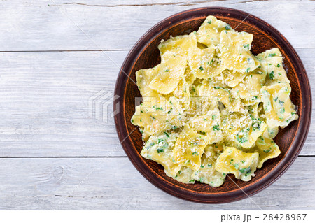 Italian ravioli smothered in creamy spinach sauce 28428967