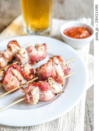 Grilled bacon skewers with chicken meat 28431486