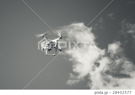 White quadrocopter, small drone in sky 28432577