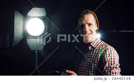 Man turning on studio light 28440138