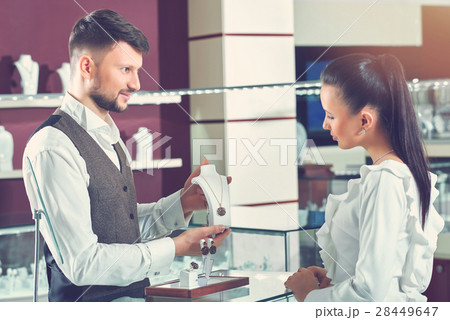 Professional male jeweler helping his female Professional male jeweler helping his female 28449647