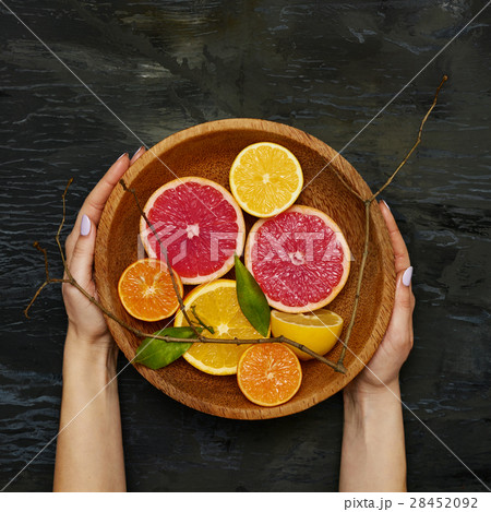Grapefruit citrus fruit halves on wooden plate Grapefruit citrus fruit halves on wooden plate 28452092