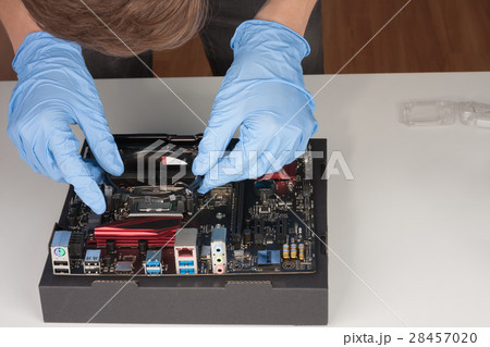 Young man with gloves installing part of CPU cooler fan. Young man with gloves installing part of CPU cooler fan. 28457020