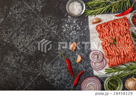 Raw minced meat on paper with onion, herbs and Raw minced meat on paper with onion, herbs and 28458129