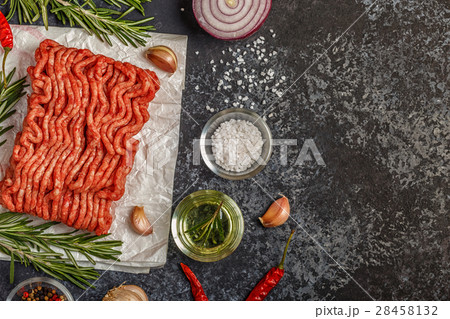 Raw minced meat on paper with onion, herbs and 28458132