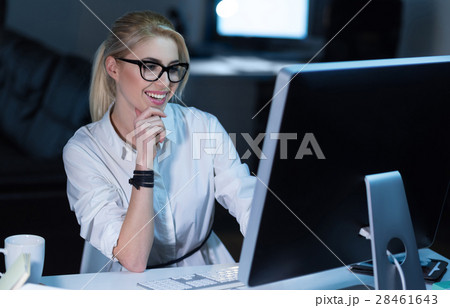 Cheerful young office worker programming in the Cheerful young office worker programming in the 28461643