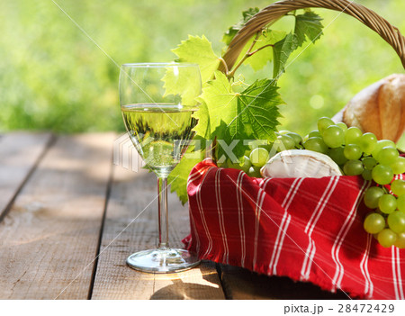 Cheese, grapes, bread two glasses of  white wine 28472429