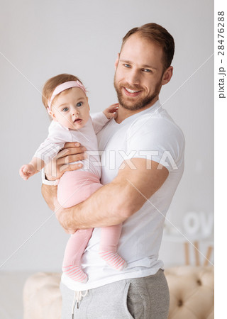 Glad young father hugging his toddler girl at home 28476288
