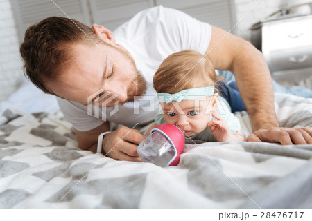 Careful father feeding his daughter at home 28476717