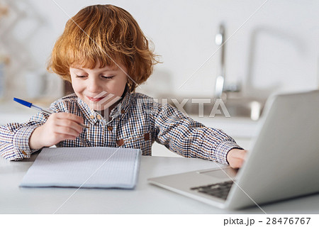 Bright intelligent child doing his homework Bright intelligent child doing his homework 28476767