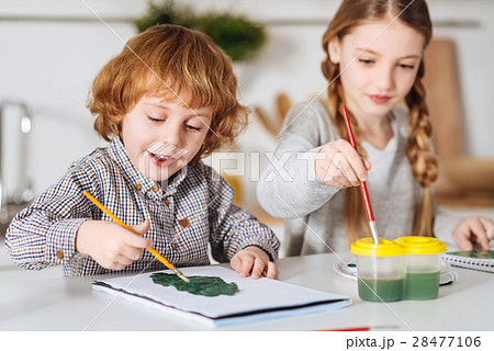 Determined little artist painting a tree 28477106