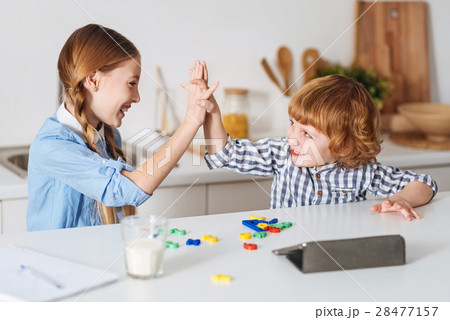 Lively positive siblings giving a high five Lively positive siblings giving a high five 28477157