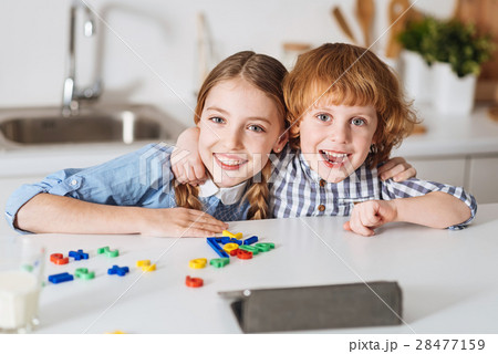 Charming positive kids sitting together at the 28477159