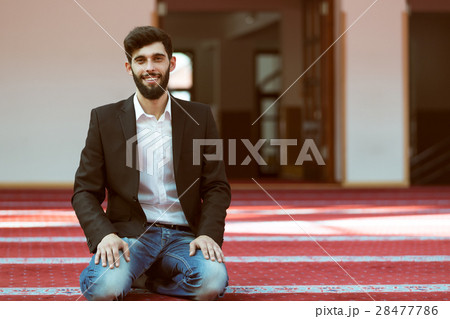 Younger Muslim man praying in colorful mosque 28477786