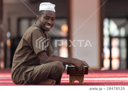 Black African Muslim Man Reading Holy Islamic Book 28478520