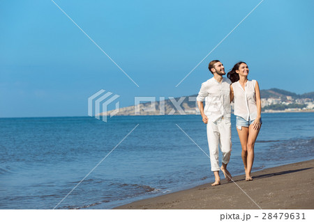 Couple walking on beach. Young happy interracial 28479631