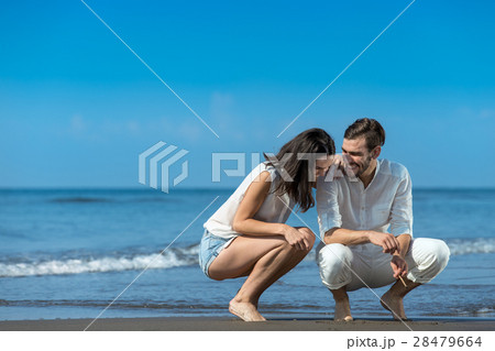 Romantic young couple draw shapes in the sand Romantic young couple draw shapes in the sand 28479664