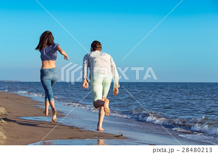 happy couple running on the beach 28480213