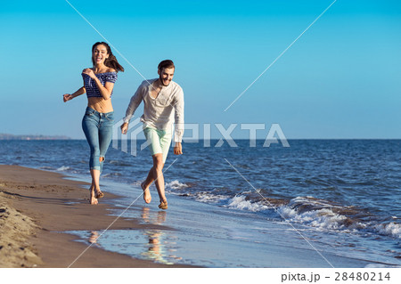 happy couple running on the beach 28480214