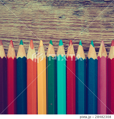 Row of colored drawing pencils on old desk. 28482308