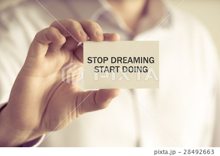 Businessman holding STOP DREAMING START DOING card 28492663