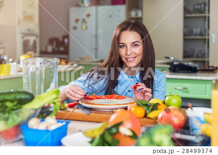 Pretty young woman smiling at camera while 28499374