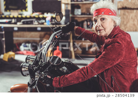 Serene pensioner locating on motorcycle in garage Serene pensioner locating on motorcycle in garage 28504139