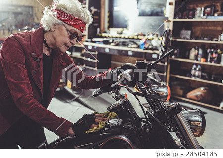 Outgoing retiree cleaning motorcycle in mechanic Outgoing retiree cleaning motorcycle in mechanic 28504185