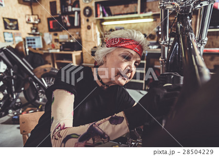 Serene female retiree making machine maintenance Serene female retiree making machine maintenance 28504229