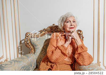 Pensive mature lady relaxing on expensive chair Pensive mature lady relaxing on expensive chair 28504522