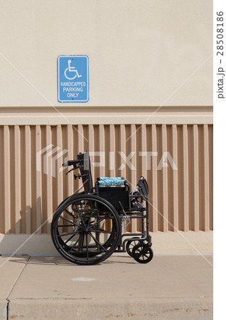 Wheelchir in front of handicapped parking sign Wheelchir in front of handicapped parking sign 28508186