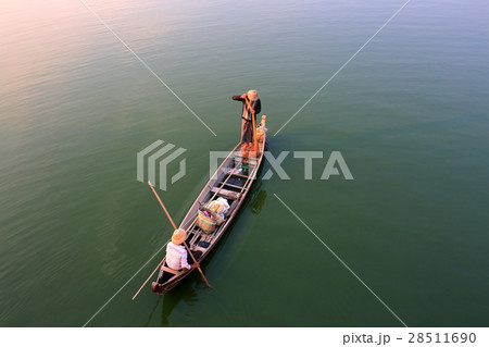 Two Burmese fishermen are fishing on a boat Two Burmese fishermen are fishing on a boat 28511690