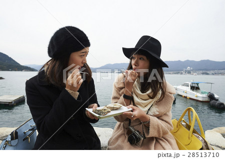 宮島　旅行　焼き牡蠣を食べる女性 28513710