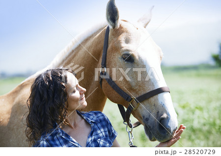Woman and horse together at paddock 28520729