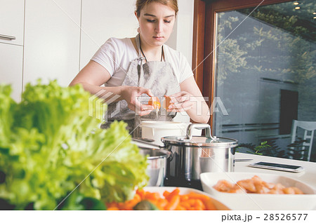 Woman stabs the eggs into the bowl to make a cake. Woman stabs the eggs into the bowl to make a cake. 28526577