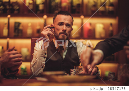 Man playing poker in gentlemen's club 28547173