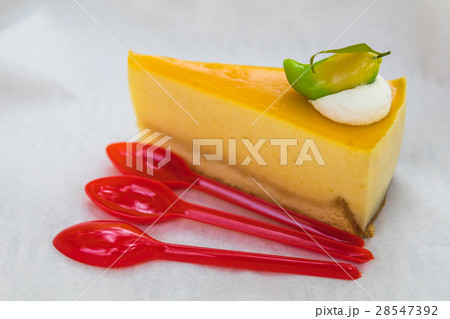 homemade mango cheesecake with red spoons homemade mango cheesecake with red spoons 28547392