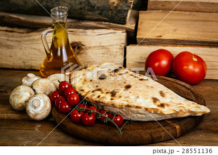 Сalzone pizza on wood table with ingredients Сalzone pizza on wood table with ingredients 28551136